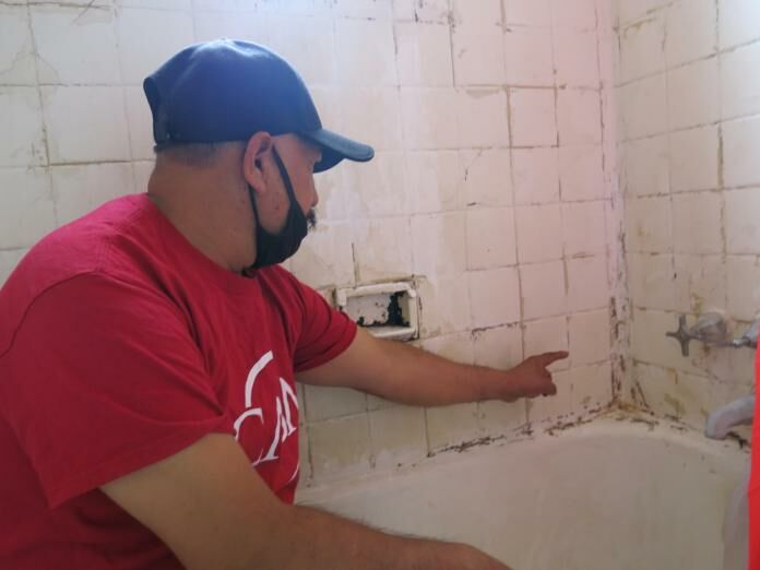 Erwin Rodas, a Bedford Station resident and plaintiff in a lawsuit challenging conditions at the property, says his bathroom is in bad shape and needs repair. Photo by Rosanne Skirble.