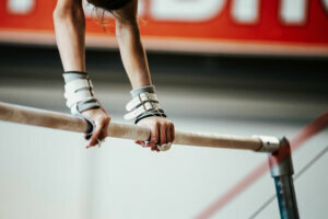 Hands young girl gymnast exercise on uneven bars