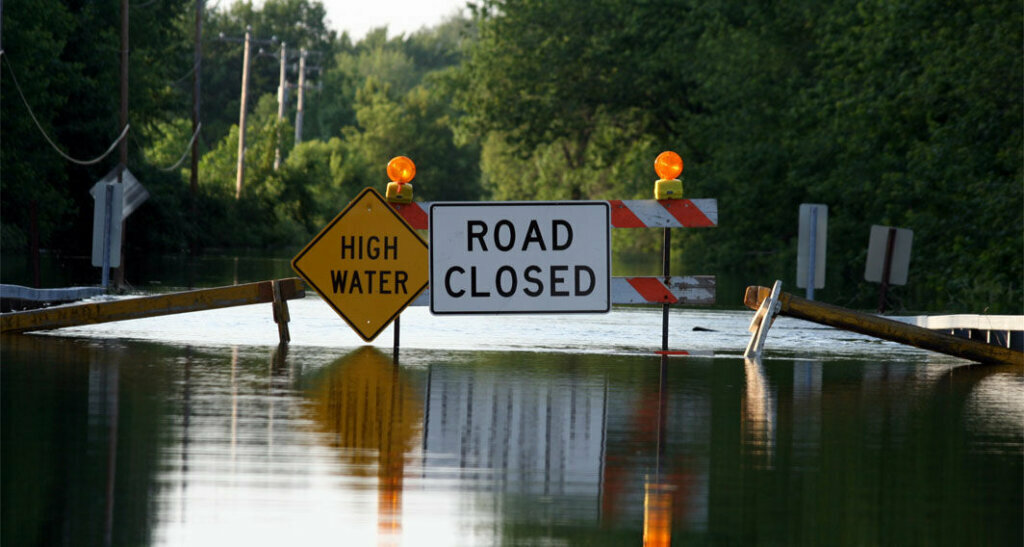 A road closure signage as water covers the road