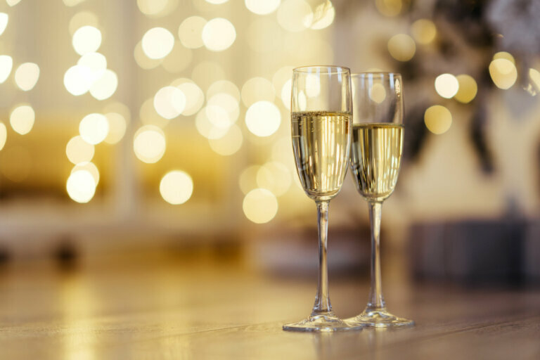 Two glasses of champagne with lights in the background.