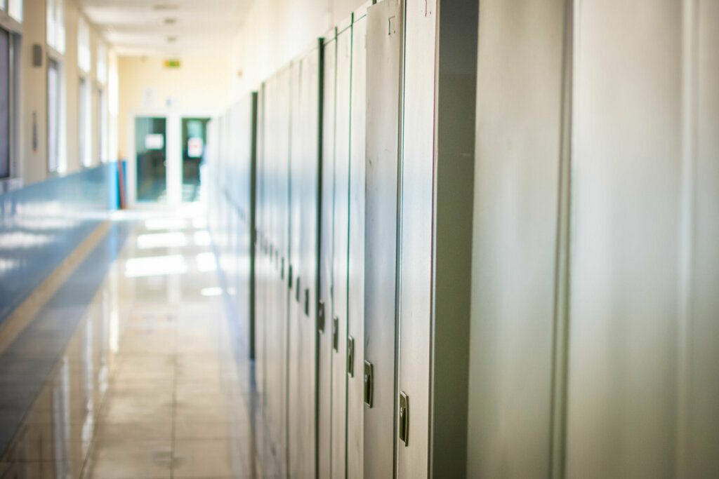 Empty hallway corridor of a high school or college closed during COVID 19 (Coronavirus). Lockers blurred into lonely hallway.