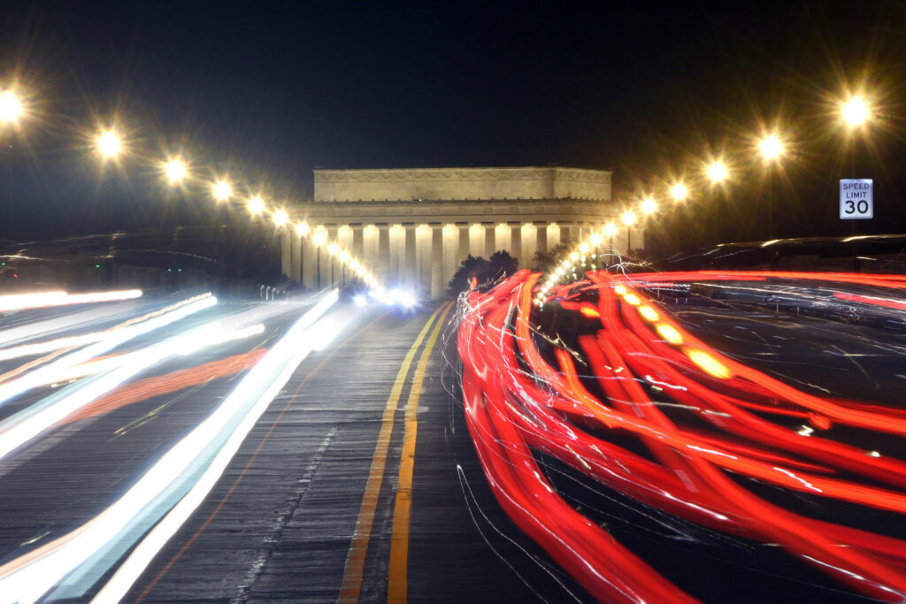 Traffic whizzes in front of the Lincoln Memorial