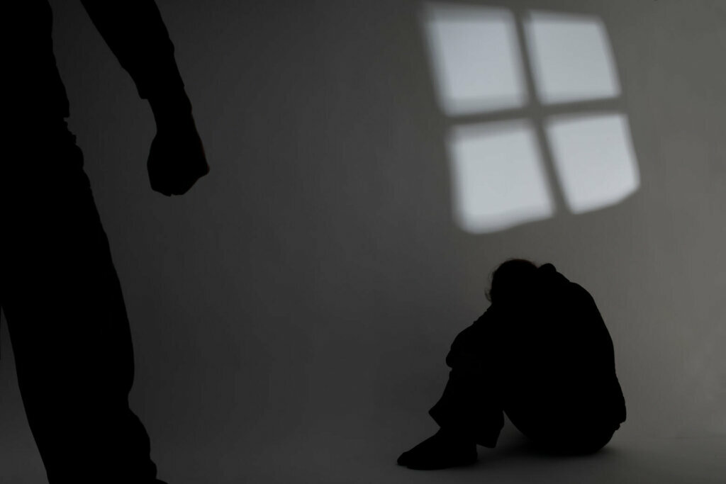 Shadow of a person in the corner hiding from abuse