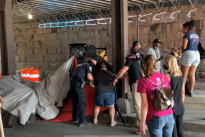 Man picked up by DC front end loader during clearing of homeless encampment.