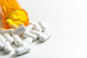 Hydrocodone capsules spilling out of a prescription bottle