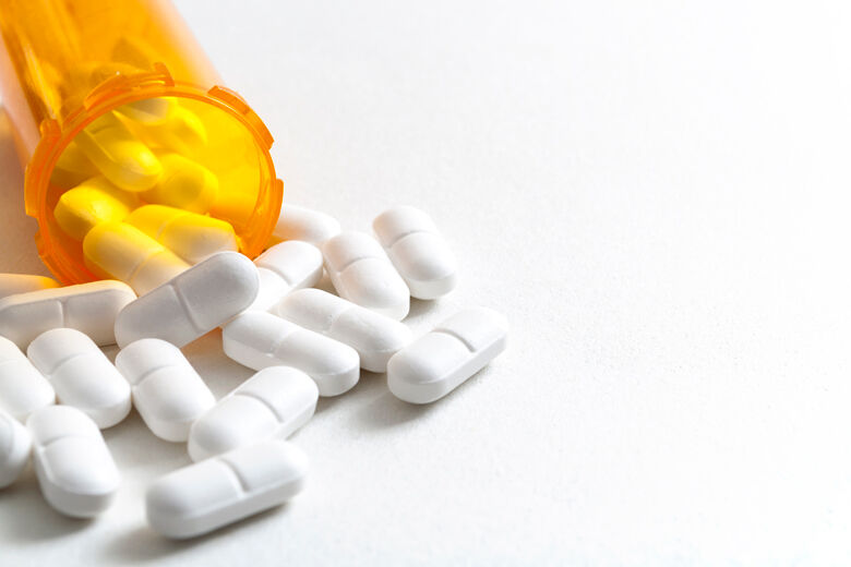 Hydrocodone capsules spilling out of a prescription bottle