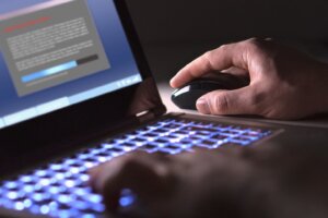 Man,Installing,Software,In,Laptop,In,Dark,At,Night.,Hacker