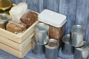 Canned food and various cereals on a wooden shelf, food crisis