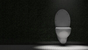 Toilet bowl in the restroom. Dramatic lighting. Copy space.