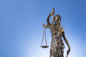 The blindfold goddess of justice Themis or Justitia on blue background