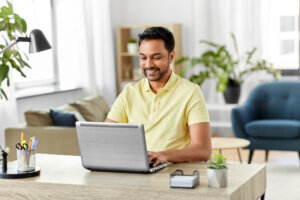 Man with laptop working at home office