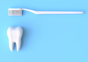 Toothbrush and white tooth on a yellow background