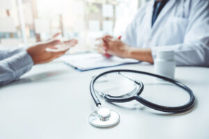 Doctors and patients consulting and diagnostic examining sit and talk. At the table near the window in the hospital medicine concept
