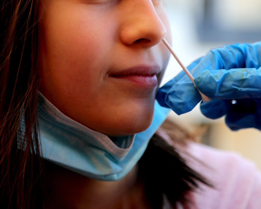 Girl while the doctor swabs her to see if she is positive for co