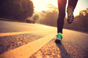 Young fitness woman runner athlete running at road