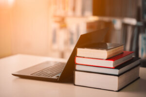 Bookshelves and laptops are placed on the library desk.E learning class and e book digital technology