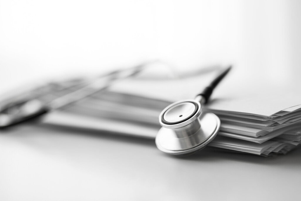Stack of report medical documents and stethoscope isolated on white background