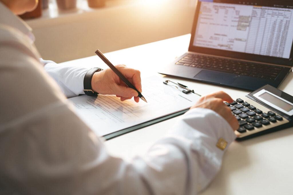 Businessman calculating the financial statement of his business. Business panoramic banner with copy space. Accounting and Tax.