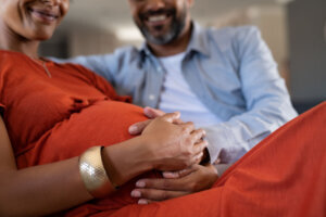 Future father feeling baby bump of pregnant woman