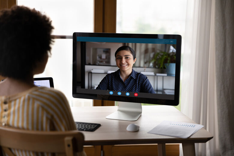 Young african woman holding video call meeting with indian colleague.