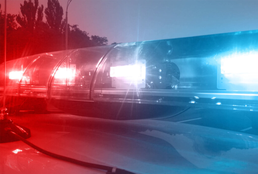 Emergency vehicle lights flashing, police car inspecting city, security service
