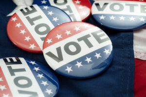 Democrat vs republican poll, democratic decision and primary voting conceptual idea with Vote election campaign button badges and the united states of american flag