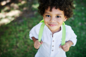 Shot of a little boy wearing a backpack in nature