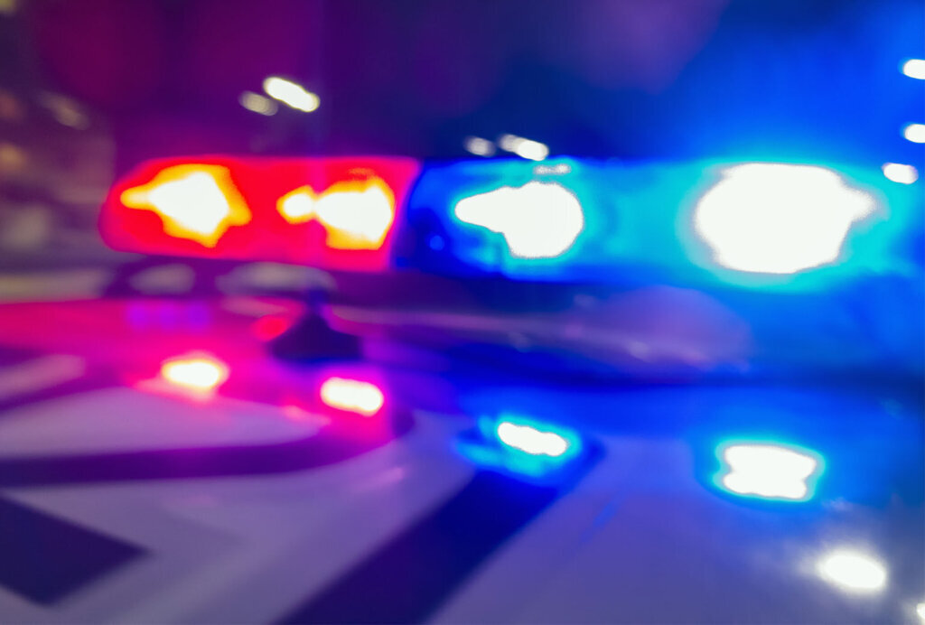 Police car lights in night time, crime scene, night patrolling the city. Abstract blurry image.