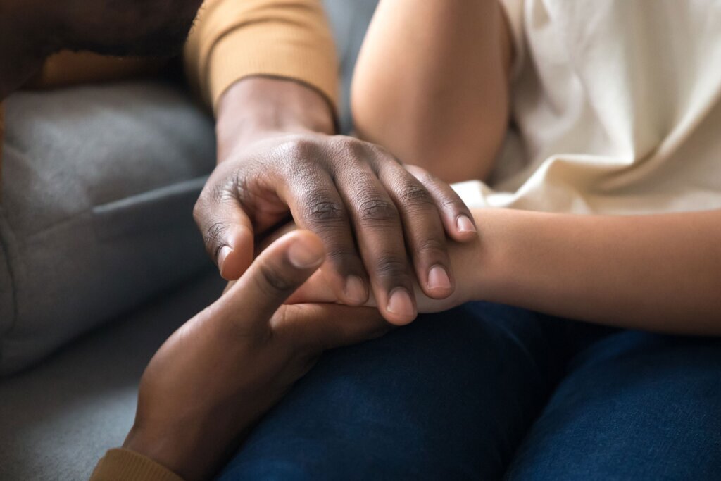 African father holding hands of child as charity support concept