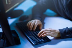 Hacker hands typing on computer keyboard
