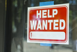 Help wanted sign in front of store front