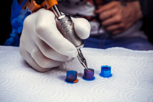 Hand of a professional tattooist with a tattoo machine