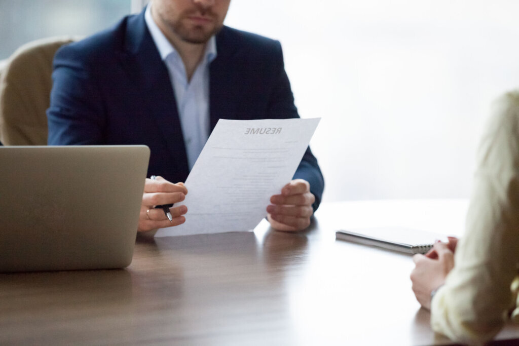 Serious HR executive interviewing woman student in office