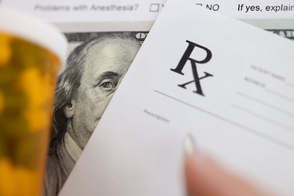 Dollar bill and doctors prescription are on doctors table in clinic closeup