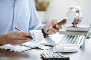 Young man holding pen with bills working for calculate business data, taxes, bills payment, Start up counting finance. accounting, statistics, and analytic research concept