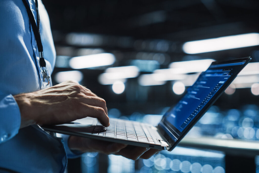 Data Center Programmer Using Digital Laptop Computer, Maintenance IT Specialist. Cloud Computing Server Farm System Administrator Working on Cyber Security for Iaas, saas, paas. Closeup Focus on Hands