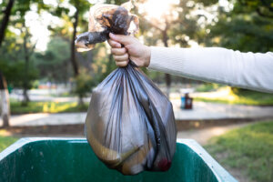 Throw the garbage bag into the trash can