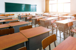 Empty classroom with desks, chairs and chalkboard