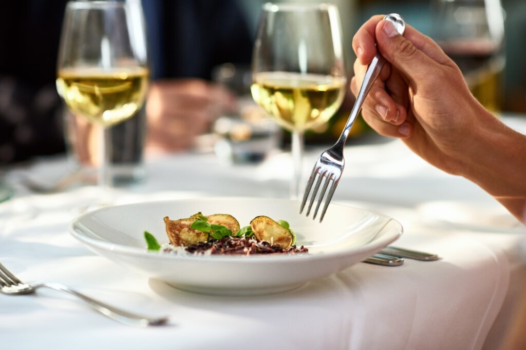 Man eating meal at table with fork