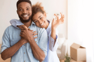 Couple Holding New Home Key Hugging Standing In Own House