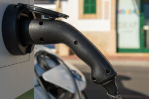 Close up of an electric car charging its battery at a charging point located in the seaport of the town of Portocolom, island of Mallorca, Spain