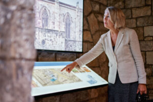 Woman at museum uses touchscreen monitor electronic guide