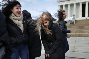 Tourists dealing with high winds on The National Mall