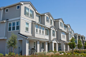 Row of three story town homes with landscaped lawns