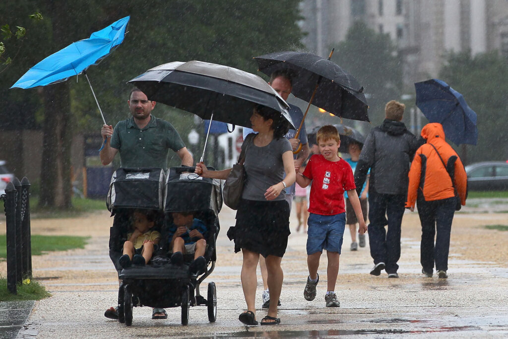 Tourists struggle against the wind and rain while visiting the nation's capital during a pouring rain and driving wind in advance of the arrival of Hurricane Irene August 27, 2011 in DC