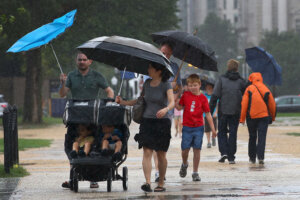 Tourists struggle against the wind and rain while visiting the nation's capital during a pouring rain and driving wind in advance of the arrival of Hurricane Irene August 27, 2011 in DC