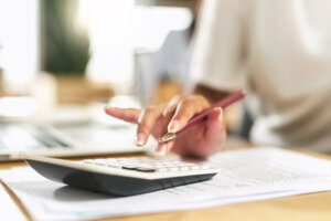 Shot of a businesswoman using a calculator to budget her finances