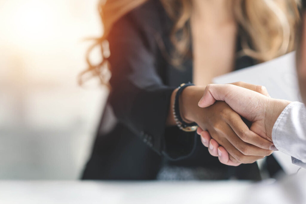 Businesspeople shake hands. (Courtesy Getty Images)