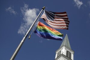 Gay Pride rainbow flag flies with the US flag