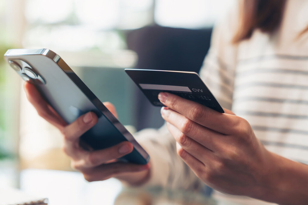 Woman hand holding credit cards and using smartphone for shopping online with payment on internet banking.